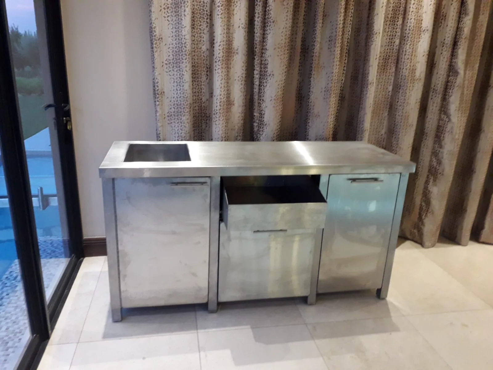 Stainless steel cabinet with inset sink, doors and drawer