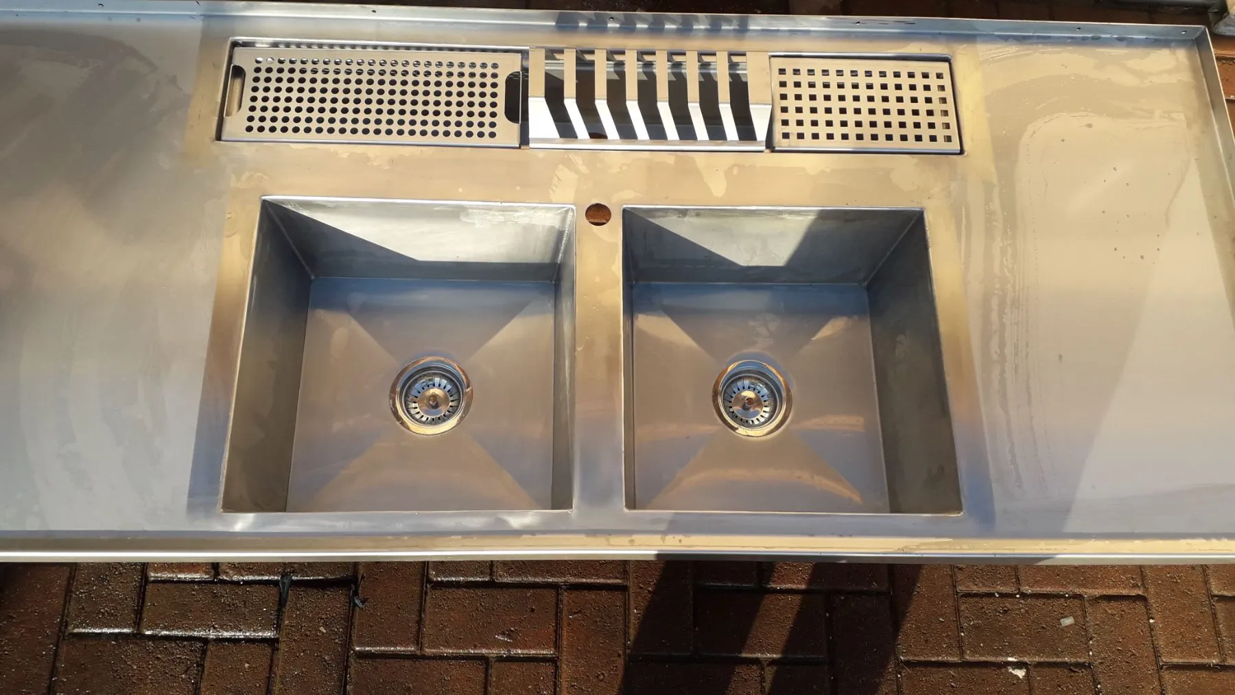 Laser welded stainless steel double bowl sink with drainer inserts, top view showing flat seams