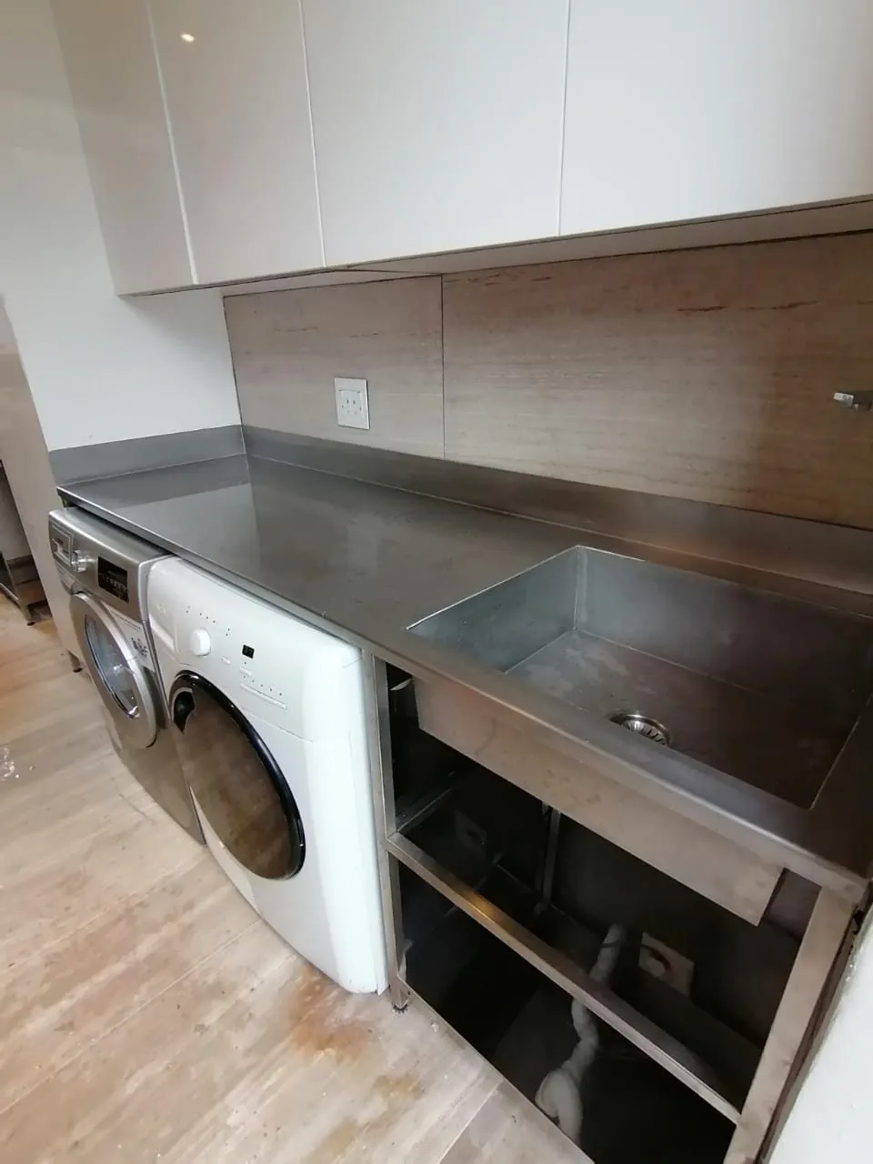 Stainless steel laundry counter with single bowl sink built to fit over existing appliances